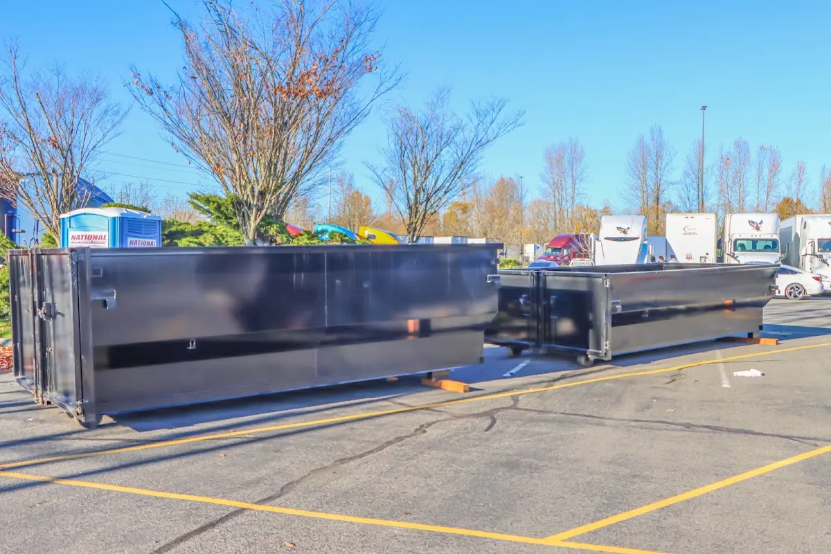 Professional dumpster rental service with roll-off container on residential driveway in Bridge City